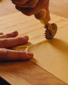 a person is working on some type of crafting project with wood and paper beads