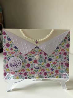 a card with an envelope and pearls attached to it that says happy birthday on the front