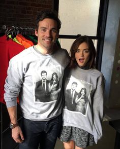 a man and woman standing next to each other wearing sweaters with photos on them