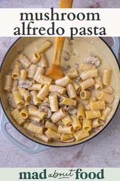 a pan filled with pasta and mushrooms on top of a wooden spoon next to the words mushroom alfredo pasta