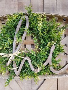 a boxwood wreath with the word love spelled out in it on a wooden crate