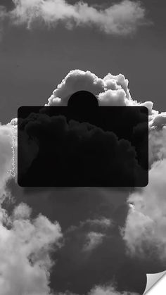 a black and white photo of clouds in the sky with an image of a sun