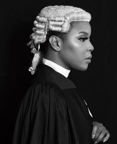 a black and white photo of a woman with long hair in a ponytail wearing a judge's robe