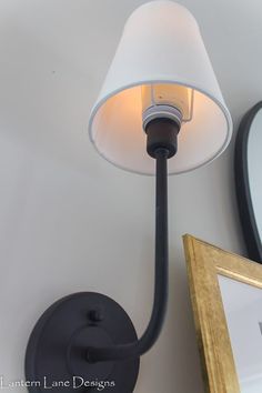 a lamp that is on the wall next to a framed photo and a light fixture