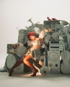 a woman standing in front of a pile of appliances