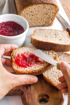 someone is slicing bread with jam on it