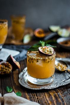 a glass filled with liquid sitting on top of a wooden table next to other dishes