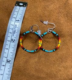 Native American inspired/designed medium beaded hoop earrings are lovingly handcrafted. They are hand beaded, one bead at a time, with glass seed beads (turquoise, black, dark red, red, dark orange, orange, yellow, silver). The hoop is 1" inch and hangs approx 1 1/4" with ear wires.

I also do custom orders / colors. These will have at least 2 days and up to a week added to the shipping time, depending on how many are needed. Southwestern Style Beaded Dangle Hoop Earrings, Handmade Small Hoop Turquoise Beaded Earrings, Festival Small Hoop Jewelry With Tiny Beads, Adjustable Round Earrings With Colorful Beads, Turquoise Beaded Small Hoop Earrings, Adjustable Colorful Beaded Round Earrings, Orange Dangle Jewelry With Black Beads, Southwestern Multicolor Nickel-free Beaded Earrings, Southwestern Style Multicolor Nickel-free Beaded Earrings