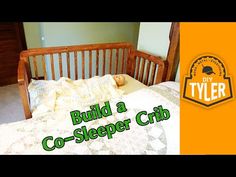 a bed with a wooden headboard and foot board in front of a yellow sign that says build a co - sleeper crib