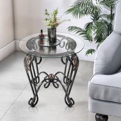 a glass table sitting next to a gray chair in a room with white walls and flooring