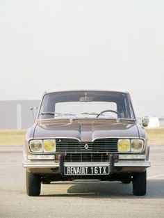 an old car is parked in the parking lot