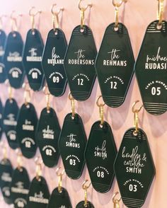 black and white tags are hanging on the wall in front of a pink wall with gold accents