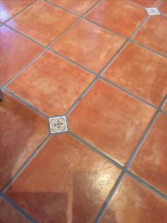 an orange tiled floor with blue lines on the edges and a white square in the middle