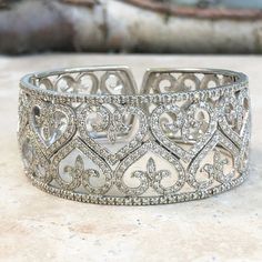 (1) Estate 14 KT White Gold & Pave  Diamond  Art Deco Filigree Hearts  Fleur de Lis Design Cuff Bangle Bracelet  Large Statement Getting Piece Many Prong Set Diamonds On a Hinge Clasp  Diamonds Go Half Way Around Back Sides is cut open Heart design pattern, minis diamonds Very Nice! Fits a 7" wrist or smaller Measures Approx 25 mm Width Tapered Back Side Very Unusual  Unique Design Weighs approx 40.30 Grams   Dramatic Effect/Look  Perfect High Fashion Piece Great Statement Piece! Great Designer Appeal! PLEASE NOTE: This listing is for (1) bracelet, other bracelets shown, Others, are NOT included, however, can be made available upon request. Please take a look at our other jewelry items. Int'l buyers, please be advised that in addition to any shipping charges they may be custom and/or broke Vintage Diamond Bracelet, Saint Jewelry, Filigree Bracelet, Diamond Bangles Bracelet, Cuff Bangle Bracelet, Bracelet Cuff, Fine Jewelry Bracelets, Gold Filigree, Diamond Bangle