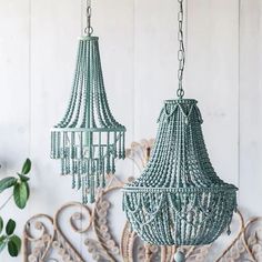 two green chandeliers hanging from a white wall