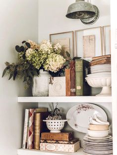 the shelves are filled with books, plates and vases on top of each other