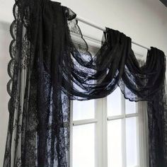 black lace curtains are hanging on the window sill in front of an open window