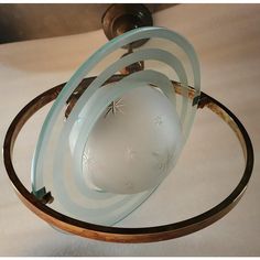 a glass ball is sitting on top of a wooden stand with two rings around it