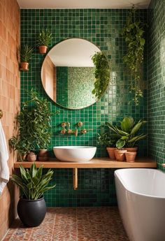 a bathroom with green tiles and potted plants on the counter, along with a round mirror