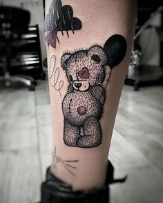 a tattoo on the leg of a person with a teddy bear