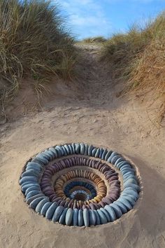 a circular sculpture made out of rocks in the sand