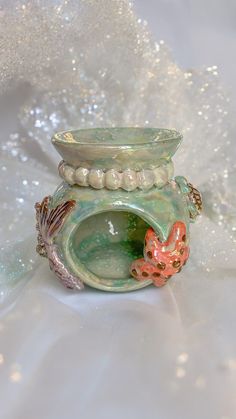 there is a small glass vase with pearls on the bottom and beads around the base