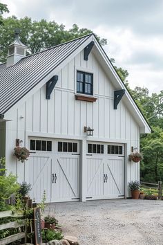 a large white barn with two garage doors