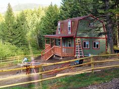 a house in the woods with stairs leading up to it