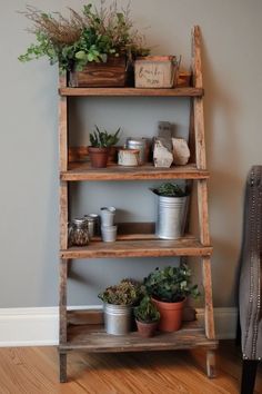 an old wooden shelf with potted plants on top and other items sitting on it