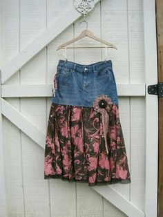 a skirt hanging on a white door with a pink and blue flowered dress underneath it