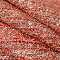 an orange and red textured fabric with small stripes on it's surface, closeup