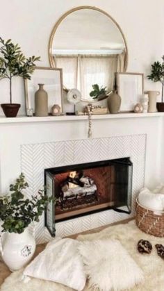 a living room with a fireplace, mirror and potted plants on the mantel