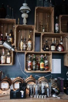 several wooden crates filled with liquor bottles on top of a counter next to a wall