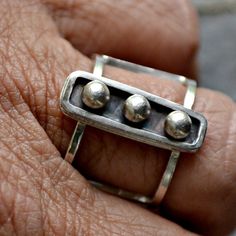 Sterling Silver and fine silver combine in a stylishly modern ring that was handmade in my studio.  I call it "Captivity".  The ring forms a cage around your finger and the 3 fine silver spheres are captive in the center portion of the ring.  It is a unique and captive-ating design.The ring is a US size 6.  The open band is just under 1/2 inch wide and the top of the ring is 2cm long or about 3/4 inch and it is 1/4 inch wide or about 6mm.  The back has a satin finish and is stamped 'sterling'. Hand Forged Modern Sterling Silver Ring, Modern Hand Forged Sterling Silver Ring, Modern Sterling Silver Hand Forged Stackable Rings, Modern Hand-forged Sterling Silver Stackable Rings, Modernist Sterling Silver Rings For Everyday, Modernist Sterling Silver Everyday Rings, Modern Hand Forged Silver Stackable Rings, Hand Forged Sterling Silver Modernist Rings, Modernist Hand Forged Sterling Silver Rings