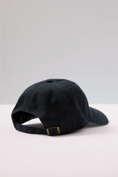 a black baseball cap with a gold buckle on the front and side, against a white background