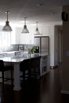 a kitchen with an island and three lights