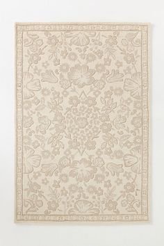 a white rug with flowers and leaves on it