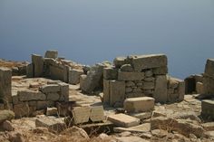 stone blocks are stacked on top of each other near the water's edge in this photo