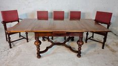 a wooden table with red chairs around it and a brick wall in the back ground