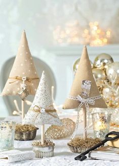 three small christmas trees sitting on top of a table next to other ornaments and decorations