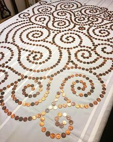 a table covered with lots of coins on top of a white table cloth in front of a window