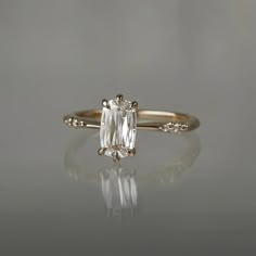 an engagement ring with a white diamond in the center and two diamonds on each side