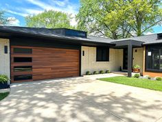 a modern home with wood garage doors and windows