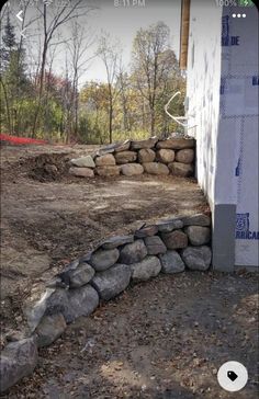 a pile of rocks sitting next to a white building with a blue tape on it