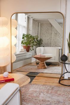 a living room filled with furniture and a large mirror on the wall next to a coffee table