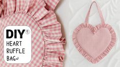 a heart shaped ruffle bag next to a pink and white checkered pillow