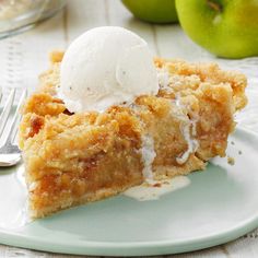 a piece of pie with ice cream on top and two green apples in the background