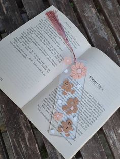 an open book with paper flowers on it and a tassel hanging from the cover