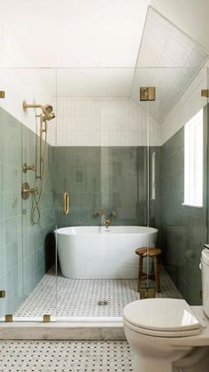 a white bath tub sitting inside of a bathroom next to a toilet and shower head