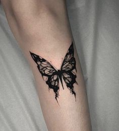 a black and white butterfly tattoo on the arm